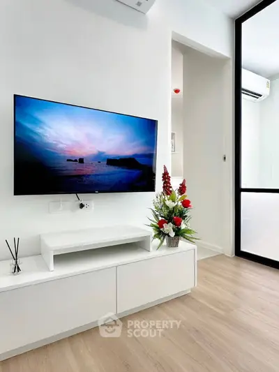 Modern living room with wall-mounted TV and elegant decor in a stylish apartment.