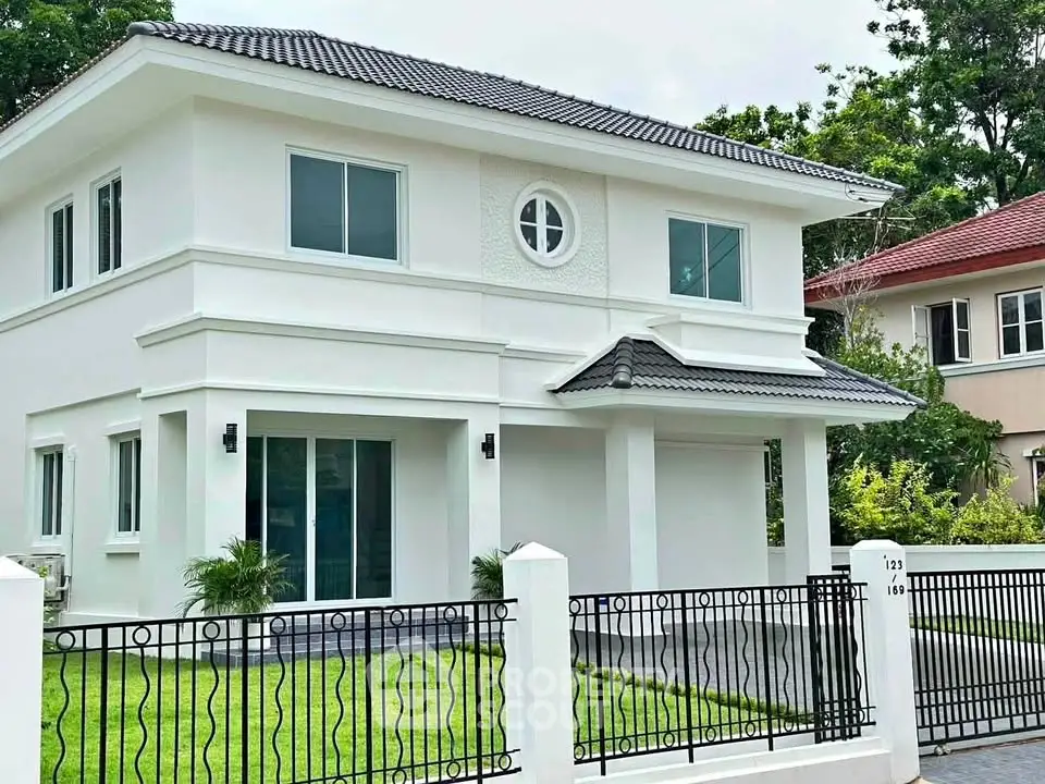 Elegant two-story white house with modern design and lush green lawn, perfect for family living.