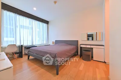 Modern bedroom with sleek furniture and large window for natural light