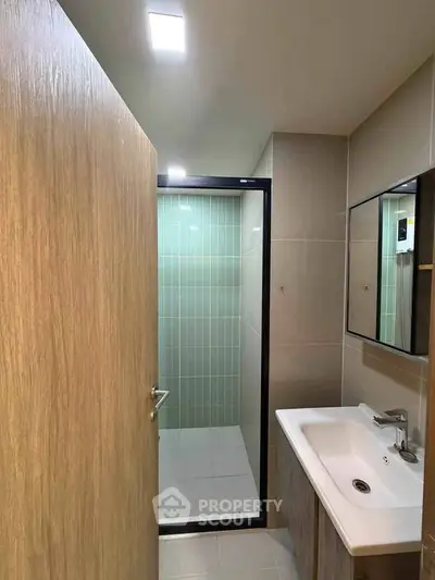 Modern bathroom with sleek shower and stylish sink in contemporary apartment.