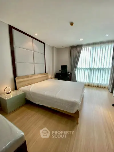 Spacious modern bedroom with large window and elegant decor