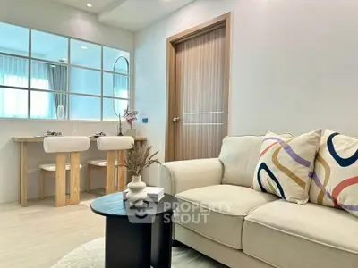 Modern living room with stylish decor and dining area, featuring a cozy sofa and elegant table setting.