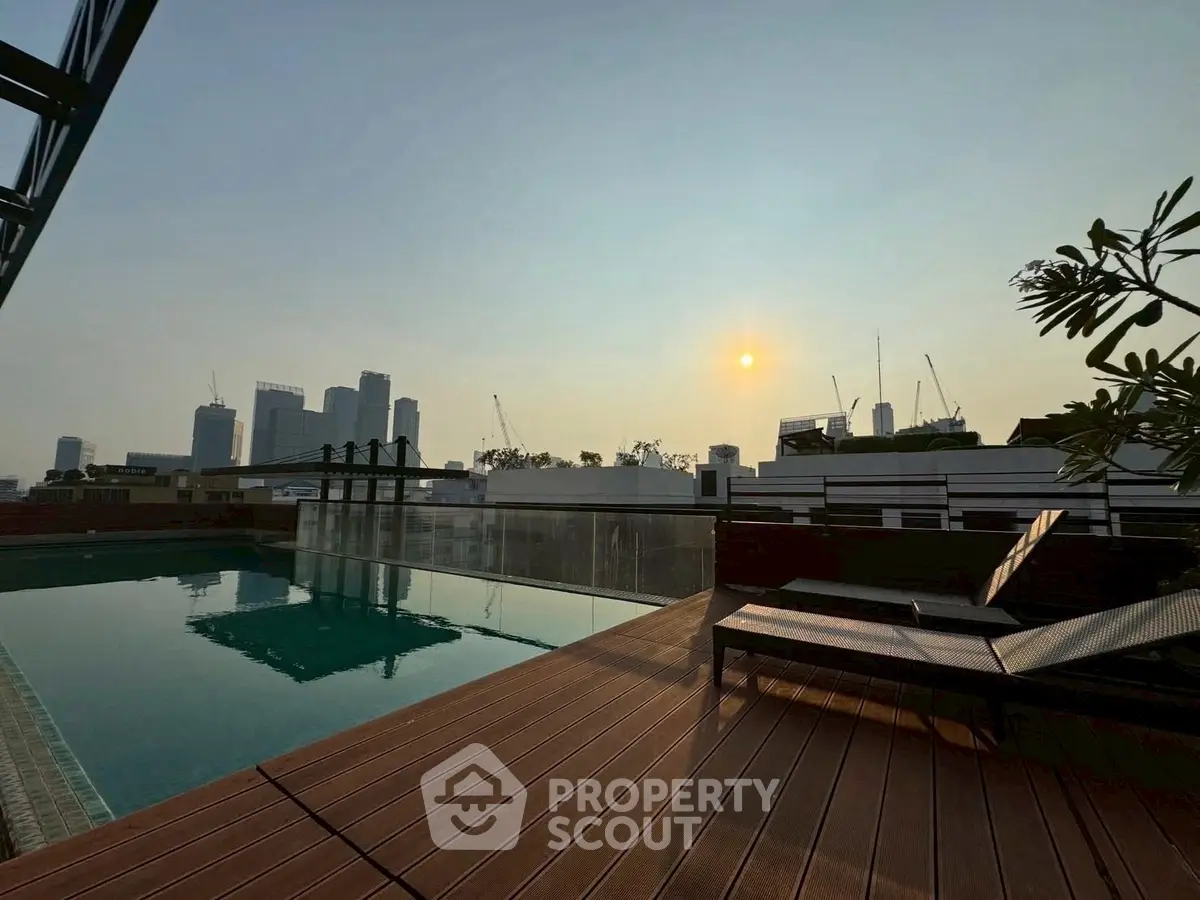 Stunning rooftop pool with city skyline view at sunset, perfect for relaxation and leisure.