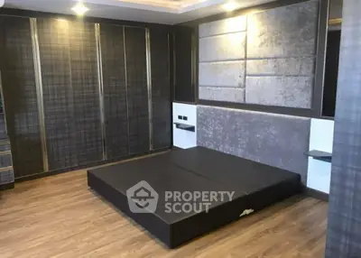 Modern bedroom with sleek design and stylish wall paneling, featuring a low-profile bed and ample closet space.