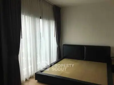 Spacious bedroom with large window and modern bed frame, perfect for natural light lovers.