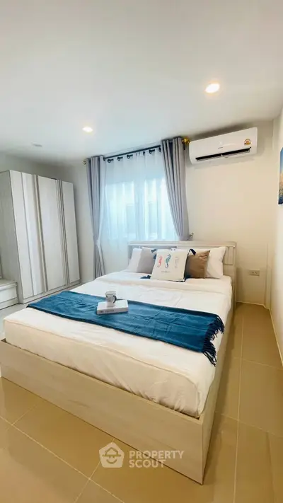 Cozy bedroom with modern decor and air conditioning, perfect for relaxation.