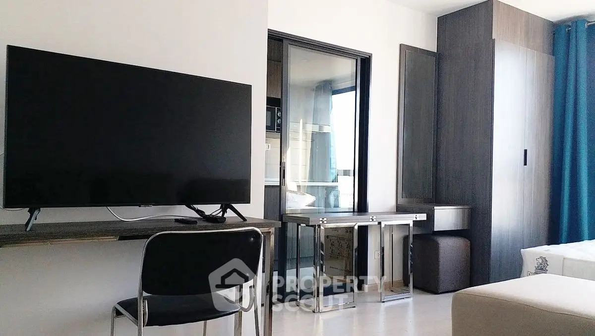 Modern studio apartment with sleek furniture and large TV