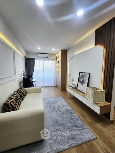 Modern living room with stylish decor, wooden flooring, and natural light