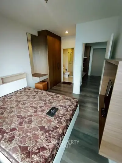 Modern bedroom with stylish decor and ensuite bathroom in a contemporary apartment.