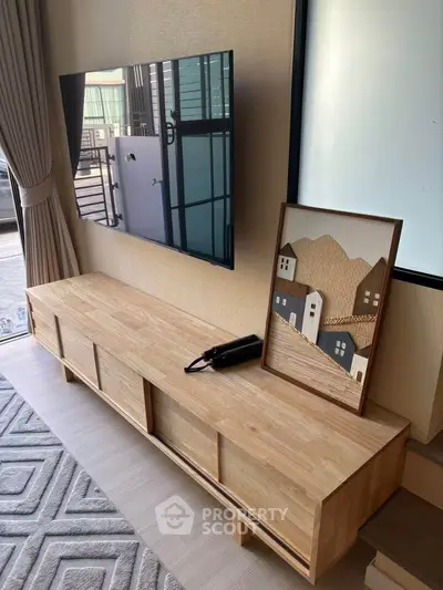 Modern living room with stylish wooden TV stand and wall-mounted flat screen.