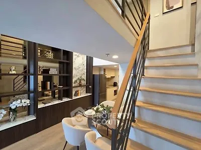 Modern duplex interior with stylish staircase and elegant dining area, perfect for contemporary living.