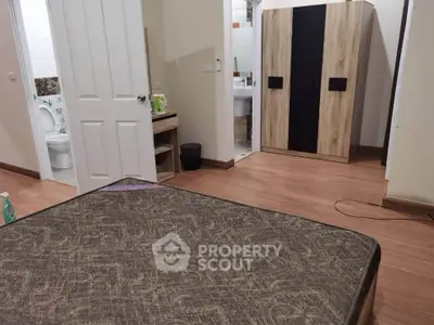 Spacious bedroom with ensuite bathroom and modern wardrobe in cozy apartment.