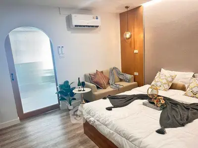 Chic bedroom with cozy seating area and modern decor, perfect for relaxation and comfort.