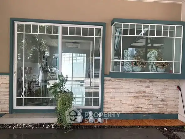 Charming exterior view of a modern home with large windows and decorative elements.