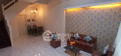 Spacious living room with elegant wallpaper and modern furniture in a stylish home.