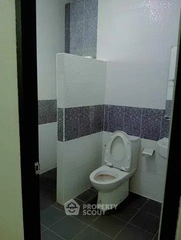 Modern bathroom with sleek tile design and contemporary toilet setup.