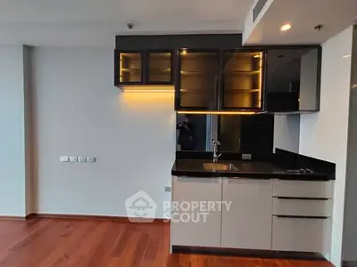 Modern kitchen with sleek cabinets and hardwood flooring in a stylish apartment.