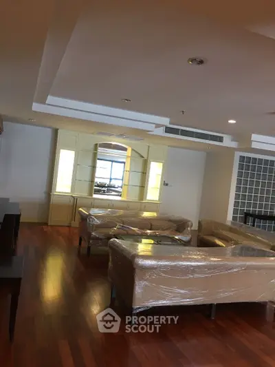 Spacious living room with elegant wooden flooring and modern furniture, perfect for relaxation and entertainment.