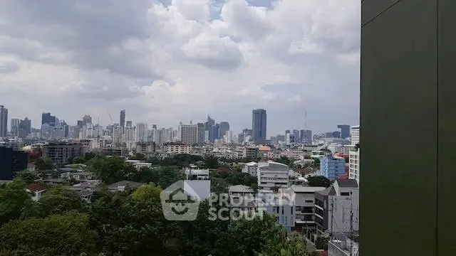 Stunning cityscape view from a high-rise building showcasing urban skyline and lush greenery.
