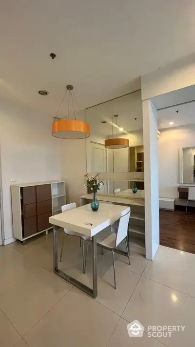 Modern dining area with sleek furniture and stylish lighting in a contemporary apartment.