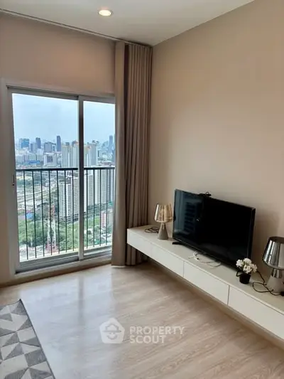 Modern living room with city view from balcony, featuring sleek TV setup and stylish decor.