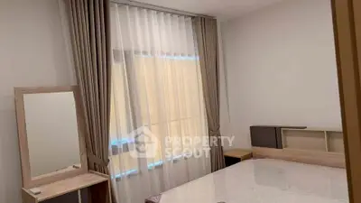 Modern bedroom with stylish curtains and wooden furniture, perfect for a cozy living space.