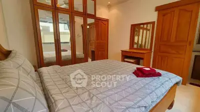 Cozy bedroom with wooden furniture and mirrored wardrobe doors
