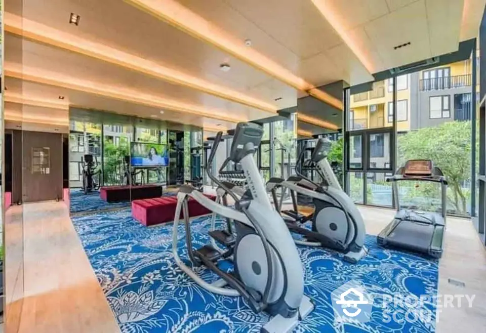 Modern gym with state-of-the-art equipment and vibrant decor in luxury residential building.