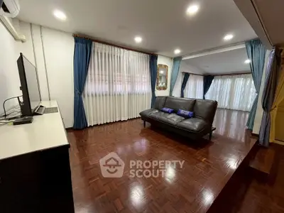 Spacious living room with elegant curtains and polished wooden flooring