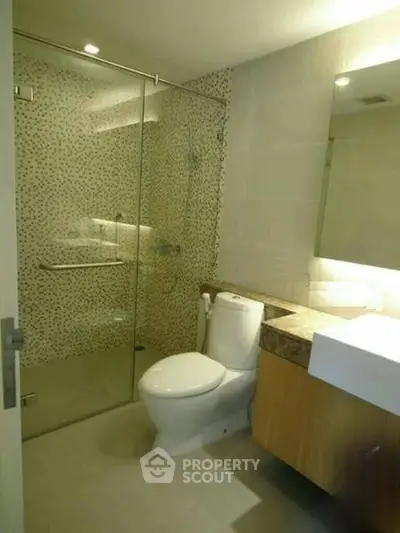 Modern bathroom with glass shower and sleek fixtures in a contemporary apartment.