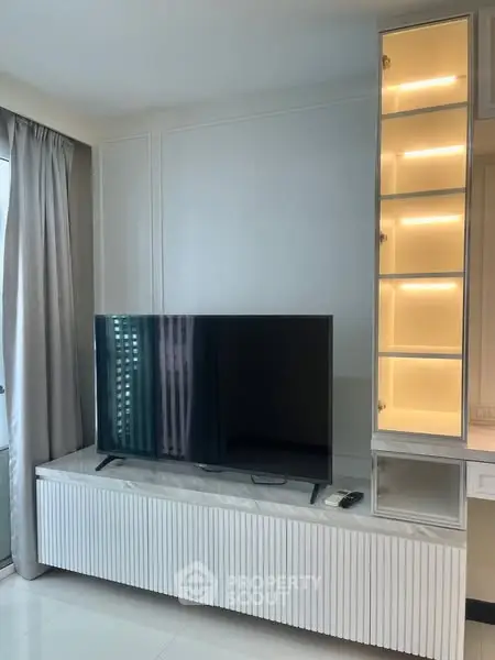 Modern living room with sleek TV unit and illuminated shelves
