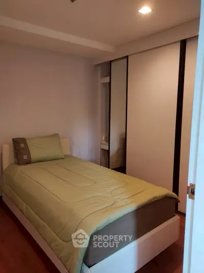 Cozy bedroom with single bed and built-in wardrobe, perfect for small spaces.