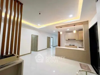 Spacious modern living room with open kitchen and elegant lighting