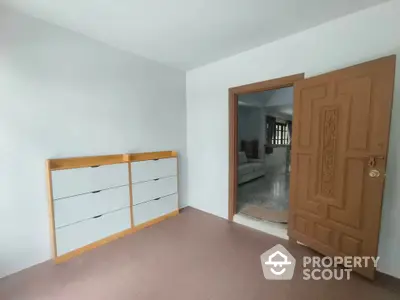 Spacious interior room with wooden door and modern storage unit