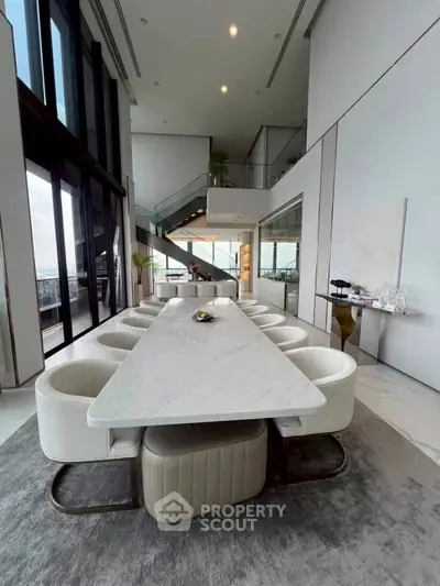 Luxurious modern dining area with high ceilings and elegant decor in a spacious apartment.