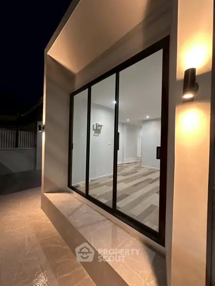 Modern exterior view with large glass sliding doors and ambient lighting
