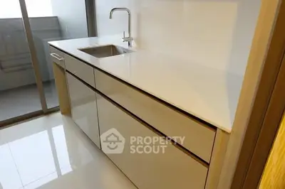 Modern kitchen with sleek white cabinetry and integrated sink