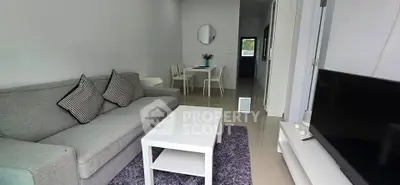 Modern living room with cozy gray sofa and sleek white furniture in a stylish apartment.