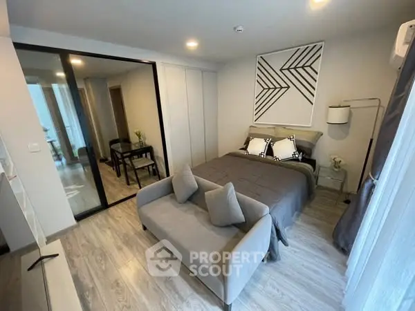 Modern bedroom with stylish decor and cozy seating area in a contemporary apartment.