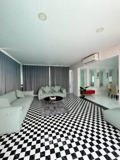 Spacious modern living room with stylish black and white checkered flooring and elegant furniture.