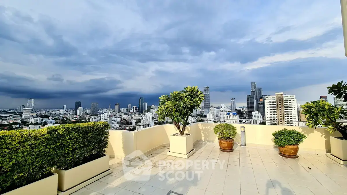 Stunning rooftop terrace with panoramic city skyline views and lush greenery.
