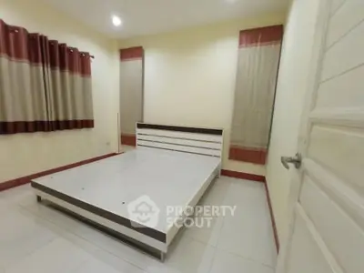 Spacious bedroom with modern bed frame and elegant curtains