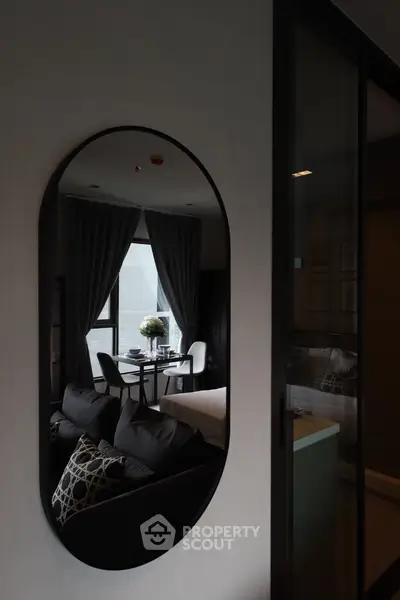Modern living room with stylish decor and large window view.