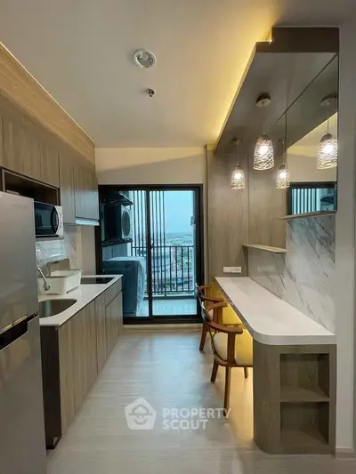 Modern kitchen with open layout and stylish lighting, featuring a balcony view.