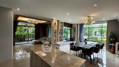 Spacious open-plan living and dining area with modern decor and large windows overlooking greenery.