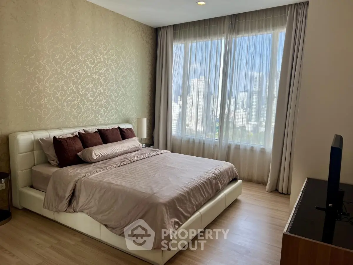 Luxurious bedroom with city view, elegant decor, and natural light
