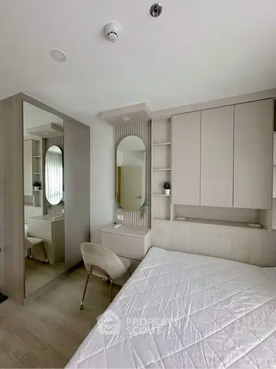 Modern bedroom with sleek design, featuring built-in storage and a stylish vanity area.