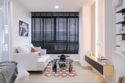 Modern living room with stylish decor and large windows featuring black blinds.