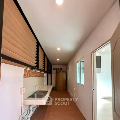 Spacious kitchen with modern sink and ample natural light, perfect for culinary enthusiasts.