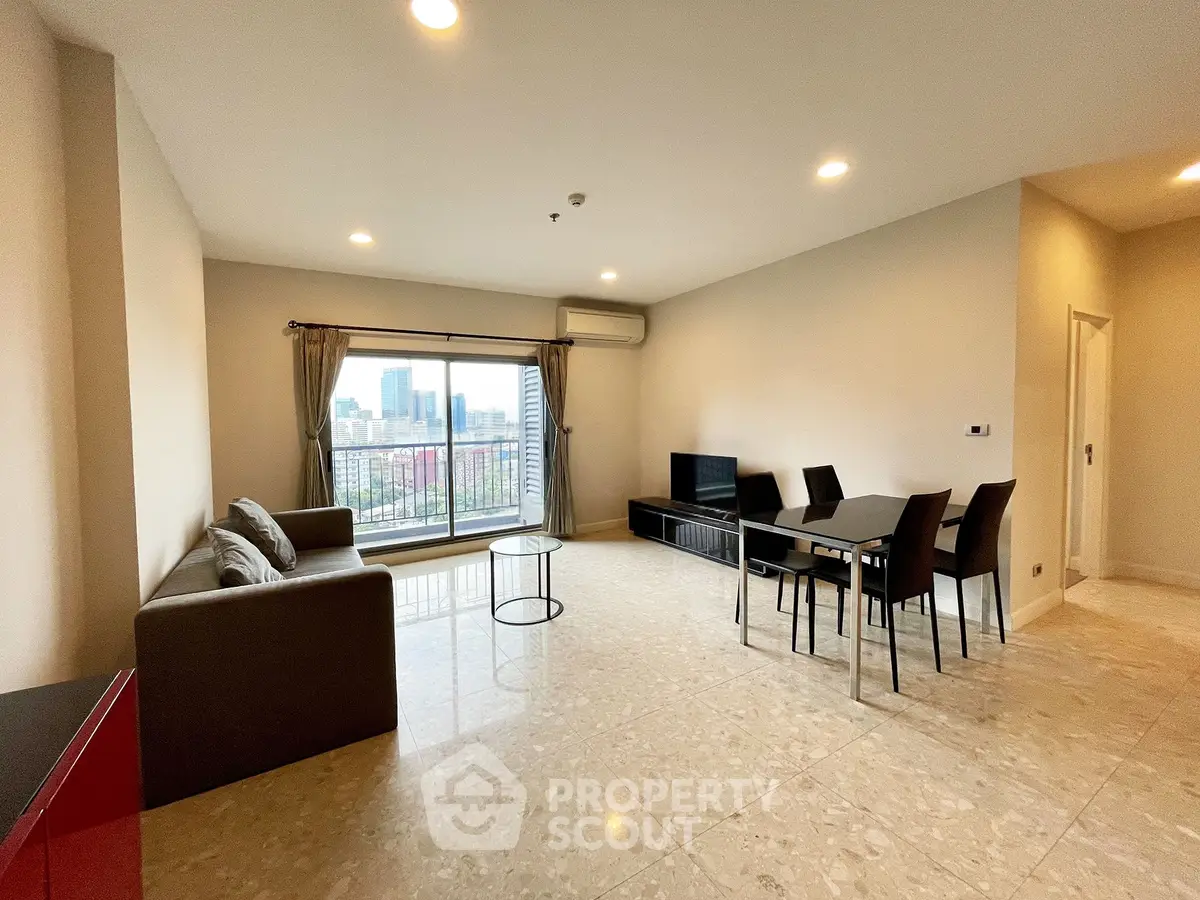 Spacious living room with city view, modern furniture, and ample natural light in a high-rise apartment.